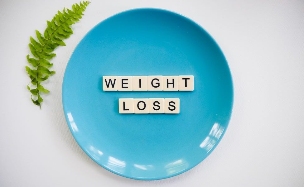 Weight loss on a blue plate spelt with scrabble letters