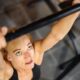 Woman gripping pull-up bar and looking up at it