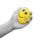 hand squeezing a stress ball with a smiley face on it