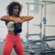 Woman performs upright row exercise with a kettlebell in the gym