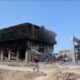 A person walks past destroyed buildings in Khan Younis