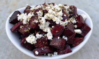 Air fryer crispy beets with crumbled feta and oregano in small white serving bowl.