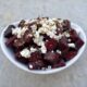 Air fryer crispy beets with crumbled feta and oregano in small white serving bowl.