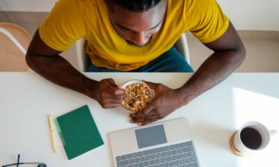 Man sitting in front of a laptop eating cereal