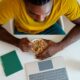 Man sitting in front of a laptop eating cereal