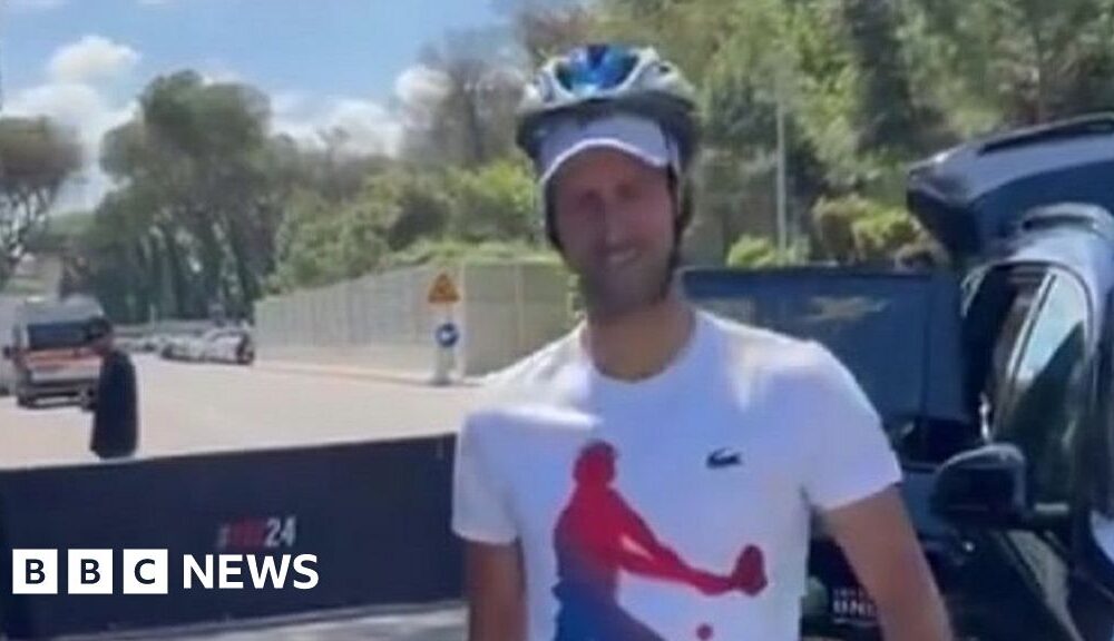 Djokovic greets fans with a helmet after being hit by bottle