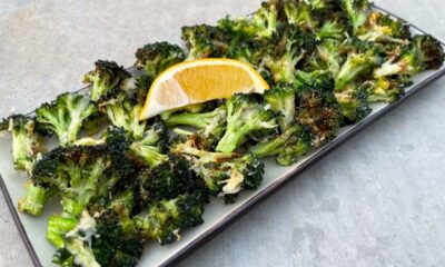 Air Fryer Roasted Garlic Parmesan Broccoli in serving dish with lemon wedge.