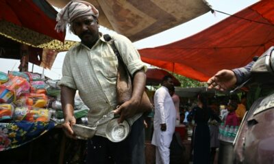 A volunteer distributes water during a hot summer day in Delhi on May 17 (Arun SANKAR)