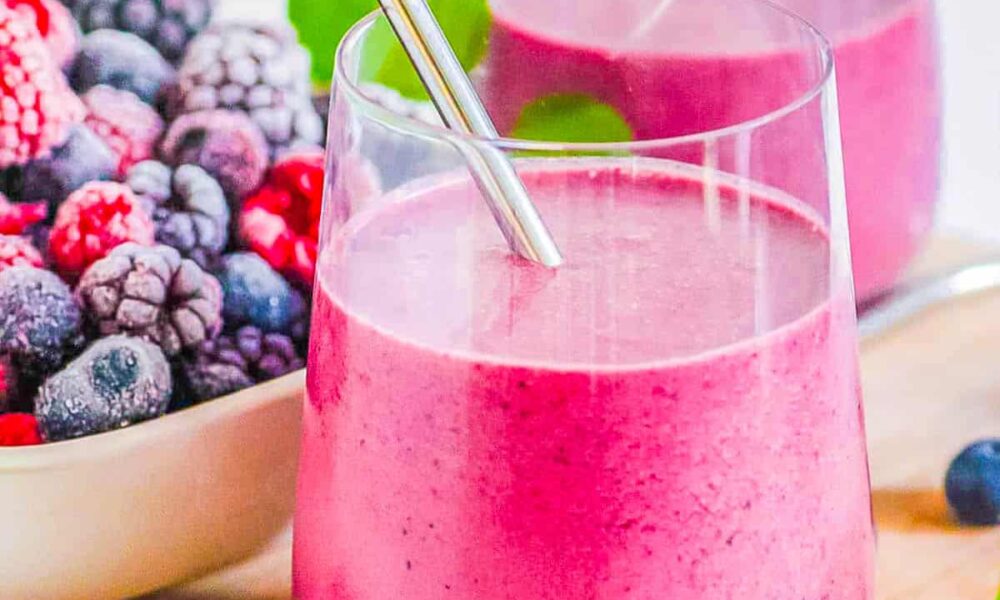 Easy healthy mixed berry smoothie served in a glass with a straw.
