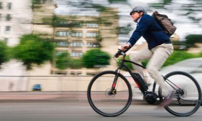 Man in casual business attire and bike helmet rides electric bike