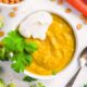 Lentils for baby served in a white bowl with some fresh herbs and veggies on the side.