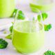 Healthy broccoli smoothie with banana in a glass on a white countertop.